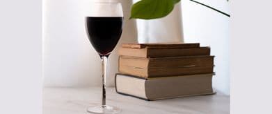 glass of wine and stack of books