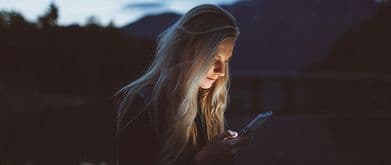 girl reading thriller book on phone