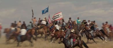 group of lakota people ride on horses in still from "lakota nation vs. united states"