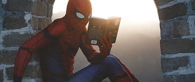 person in spiderman costume reading a book