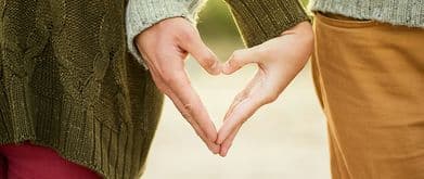 couple making a heart with their hands