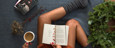 woman reading with fuzzy socks on at christmas