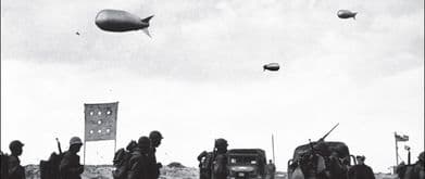 photo of troops walking with military balloons overhead